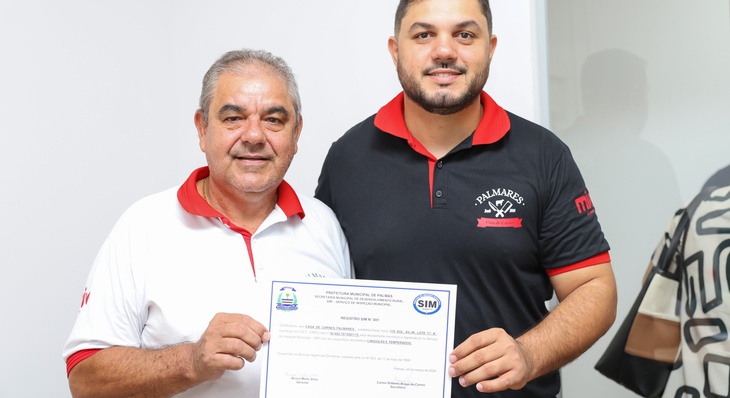 Onésio da Silva tira foto ao lado do filho com o certificado do SIM