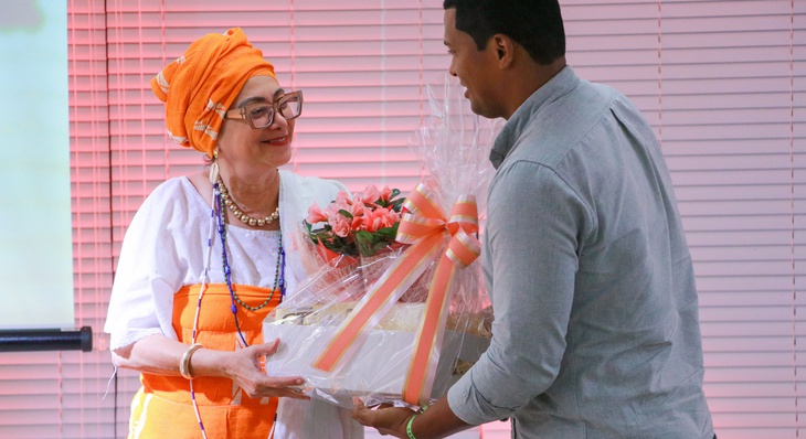Roberta de Osoguiã recebendo a homenagem do secretário executivo da FCP, Nélio Lopes