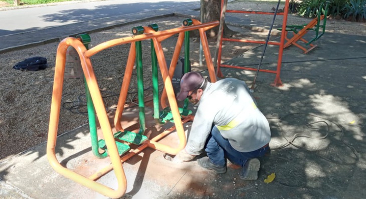 Servidor faz manutenção de equipamentos de academia de praça pública
