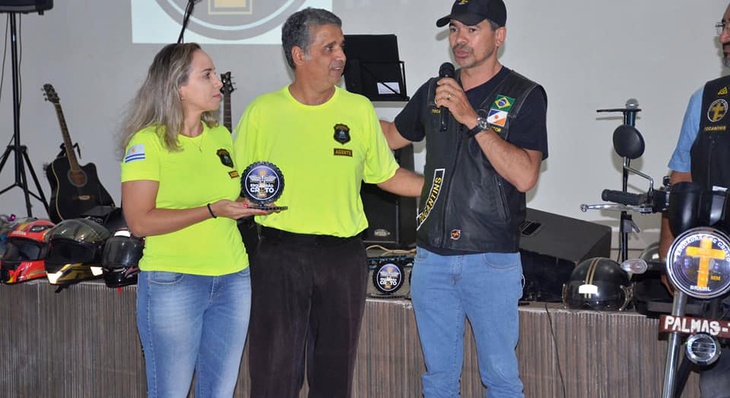 Agente Kerlen Parrião e Celestino Pessoa recebem troféu representando a Sesmu