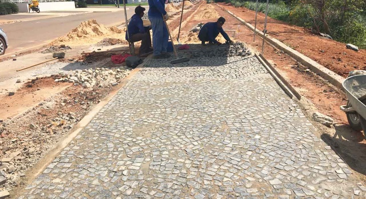 Trabalhadores realizam assentamento de pedras portuguesas em área em que estrutura da orla da Graciosa é ampliada