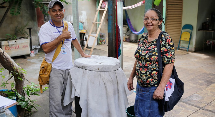 O agente Divino Maia parabeniza dona Maria Oneide pelo cuidado em cobrir o tambor que usa para água da chuva