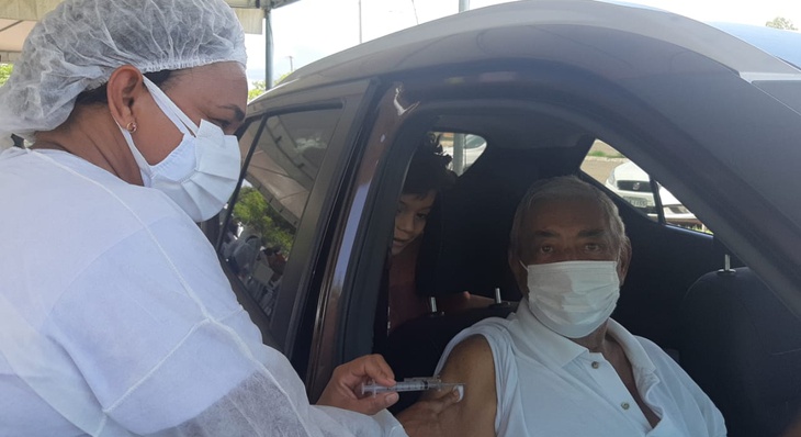 Rui Carlos Coutinho é vacinado sob o olhar atento do neto Emanuel Melchiades