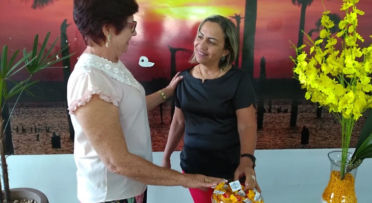 Coordenadora do Amas, Carmem Lúcia (à esq.), entrega lembrancinha à aposentada Marta Maria