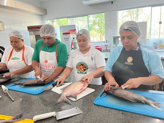 Cássia Sobreira (primeira a direita), orienta os participantes sobre como retirar o filé de peixes