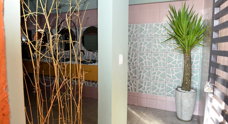 Elementos tropicais e cores suaves foram inspiração para decoração de banheiro público feminino
