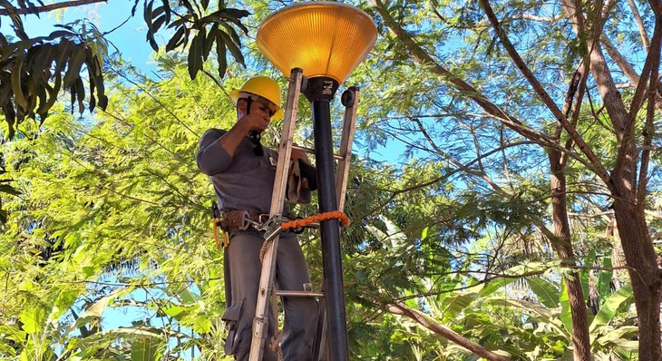 Eletricista faz manutenção em luminária de praça do Maria Rosa, nesta sexta, 23