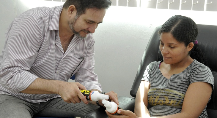 Enfermeiro Ériko Marvão orienta a gestante Adivan sobre o uso correto do repelente