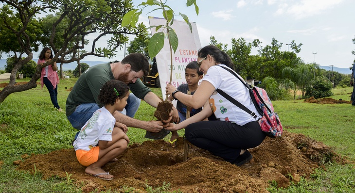 Ao lado de Marcelo Grison, professora Osita e os filhos Fernanda, 7, e Guilherme, 8, plantam uma muda de ipê em praça do Vale do Sol 