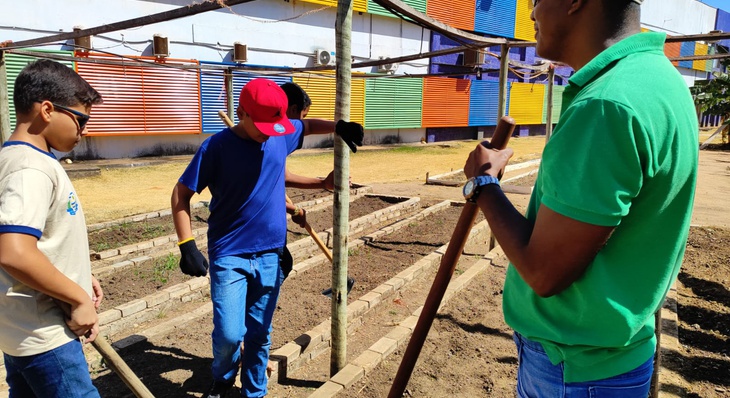 Aula prática sobre preparação do solo para plantio de hortaliças, verduras e legumes nas hortas da escola