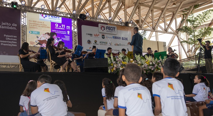 Orquestra de Cordas, composta por alunos da Escola de Tempo Integral Monsenhor Pedro Pereira Piagem, apresenta-se no palco principal do espaço.