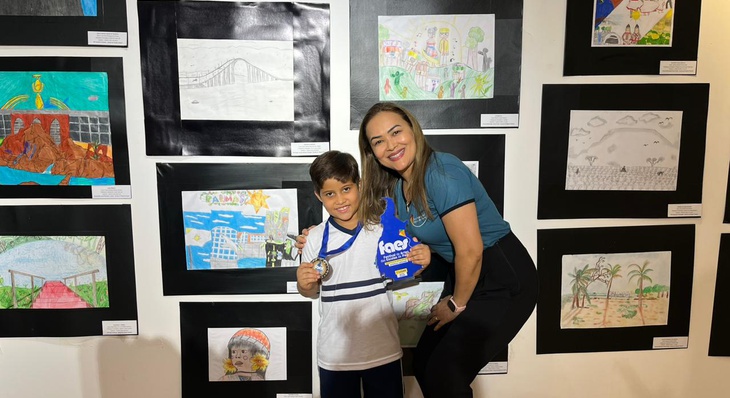 José Henrique, 1º lugar na categoria Desenho, ao lado da diretora da Escola Degraus do Saber, Welma Milhomem