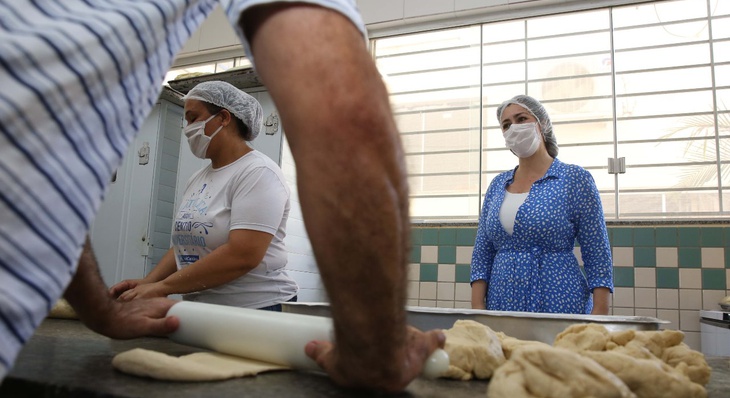 Prefeita Cinthia Ribeiro observa padeiros de ETI realizando preparo de massa de pães