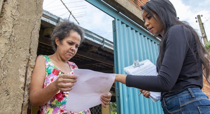 Moradora do setor Universitário, Sandra Fernandes da Silva, recebendo a notificação dos assistentes sociais