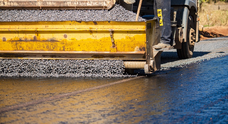 Aplicação de brita sobre selante, etapa do processo de aplicação de asfalto do tipo tratamento superficial duplo (TSD)