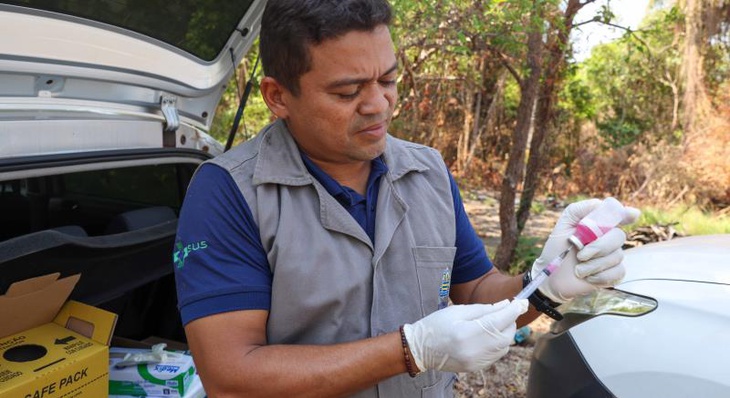 Agente de Combate de Endemias Adriano Rios durante vacinação antirrábica na zona rural