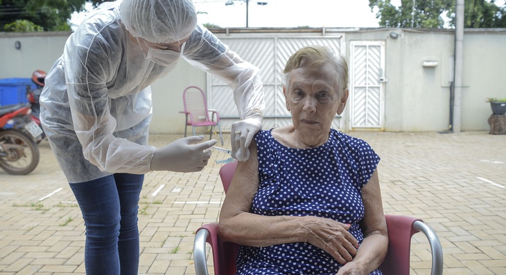 Maria Cecília Herreira, 85 anos, foi a primeira idosa do lar a receber a vacina