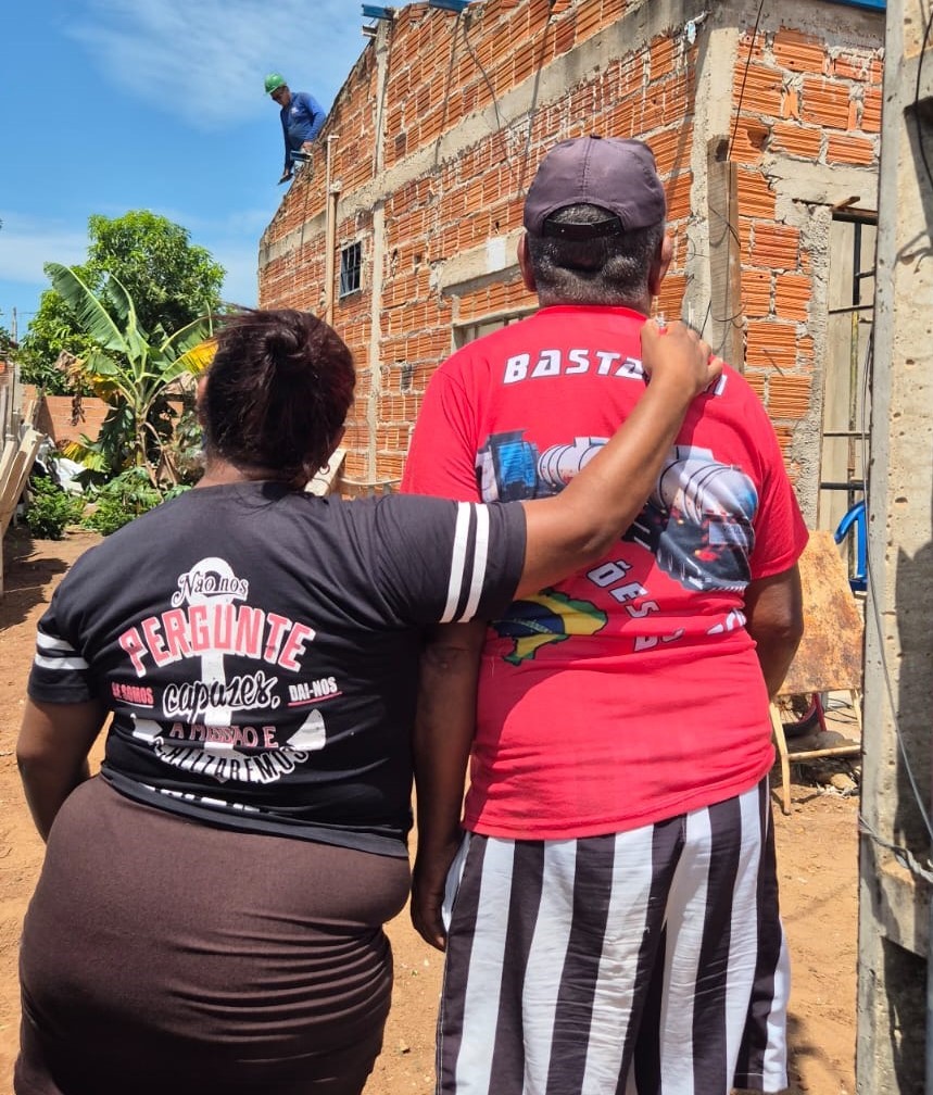 O morador Raimundo Vieira da Cunha e sua filha Fabiana acompanhando a montagem das telhas na casa atingida pelo vendaval