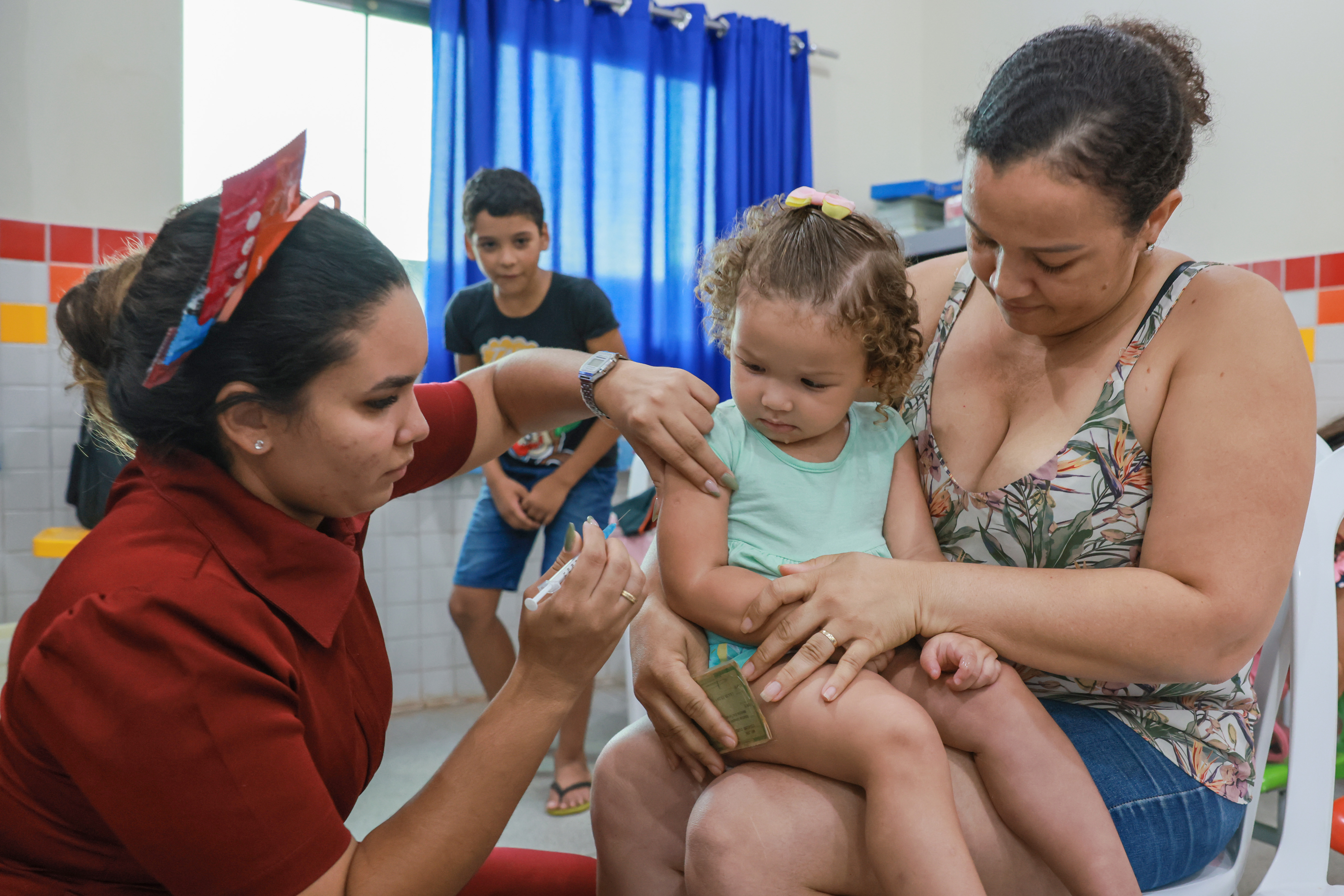 A auxiliar contábil Estelma Dias Andrade, 43 anos, moradora do Jardim Taquari, buscou a vacinação para os filhos, pois não tem disponibilidade para realizar durante a semana, ela garantiu as doses de cuidados necessários para a Gabrielly Dias de Sousa, 2 anos, 
Foto: Júnior Suzuki