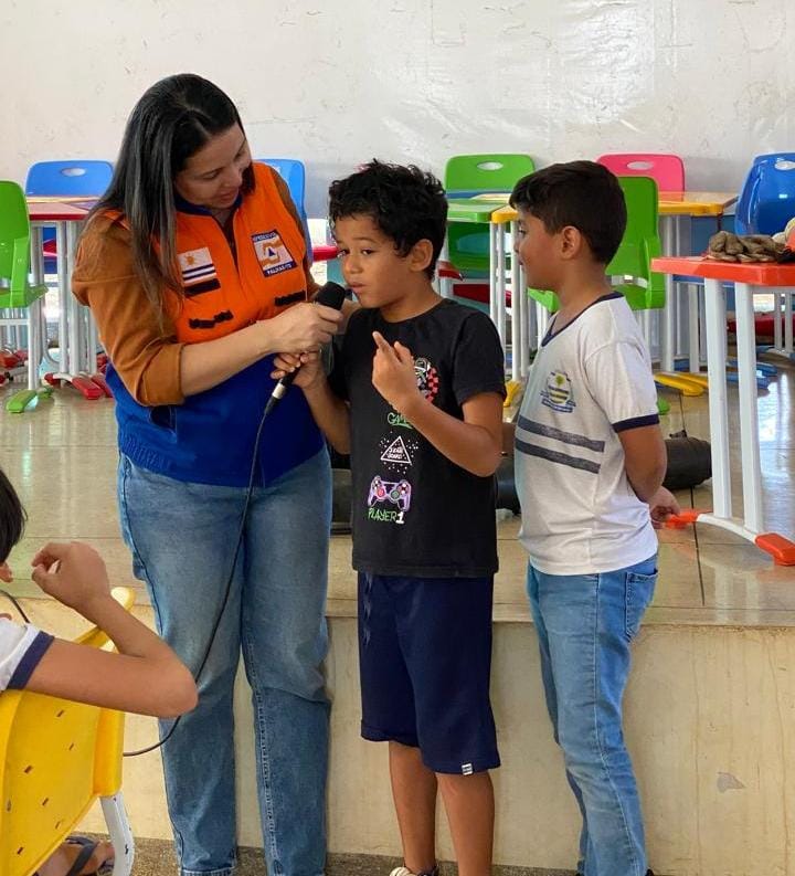 Alunos da Escola Municipal Carlos Drumond de Andrade interagem com a Educadora Social, Flavia Lustosa, da Defesa Civil Municipal