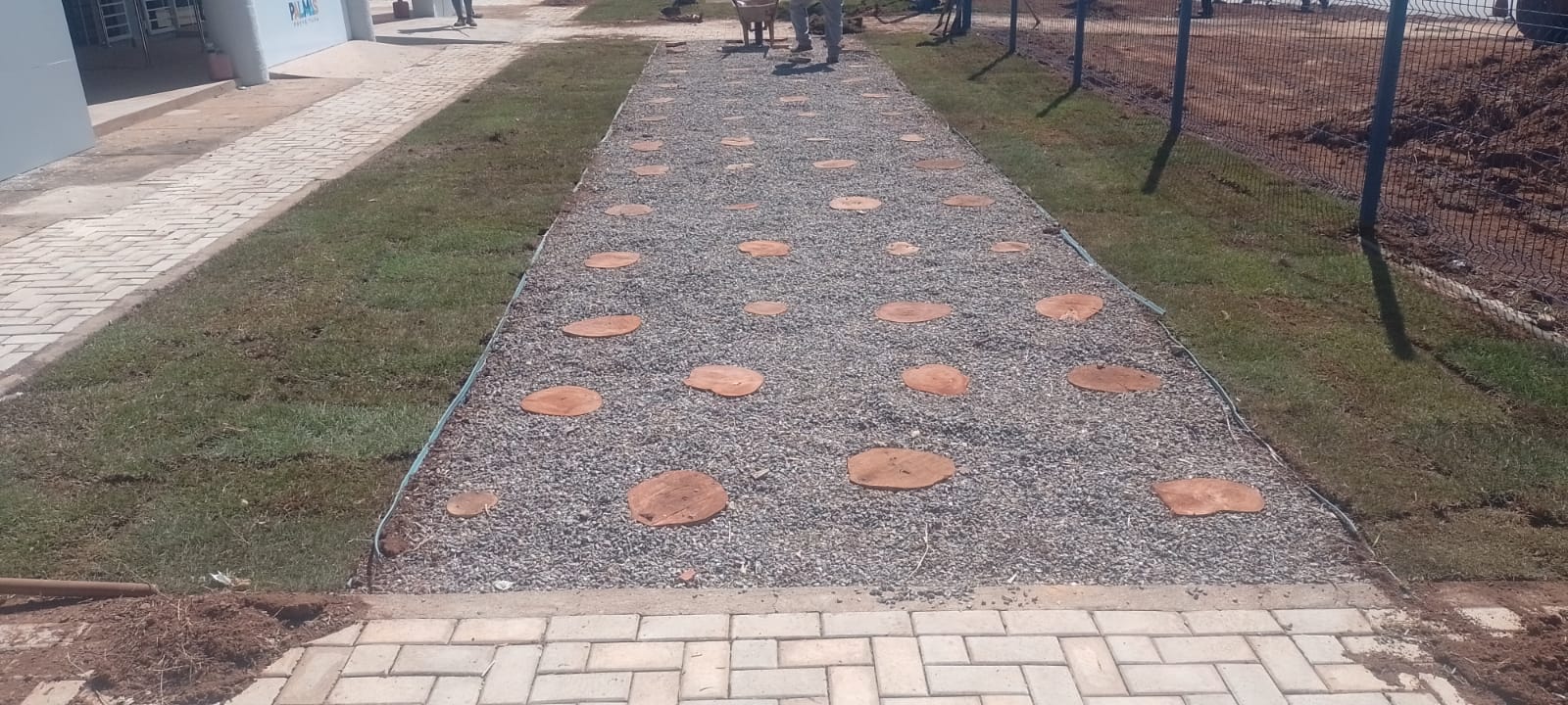 Passarela com brita e e madeiras cortadas em disco