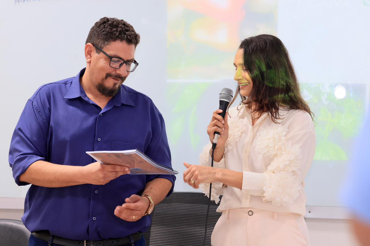 Secretário-executivo de Segurança Alimentar, Felipe Coelho, entregando o Guia à secretária de Ação Social e da Mulher, Polyanna Siqueira Campos