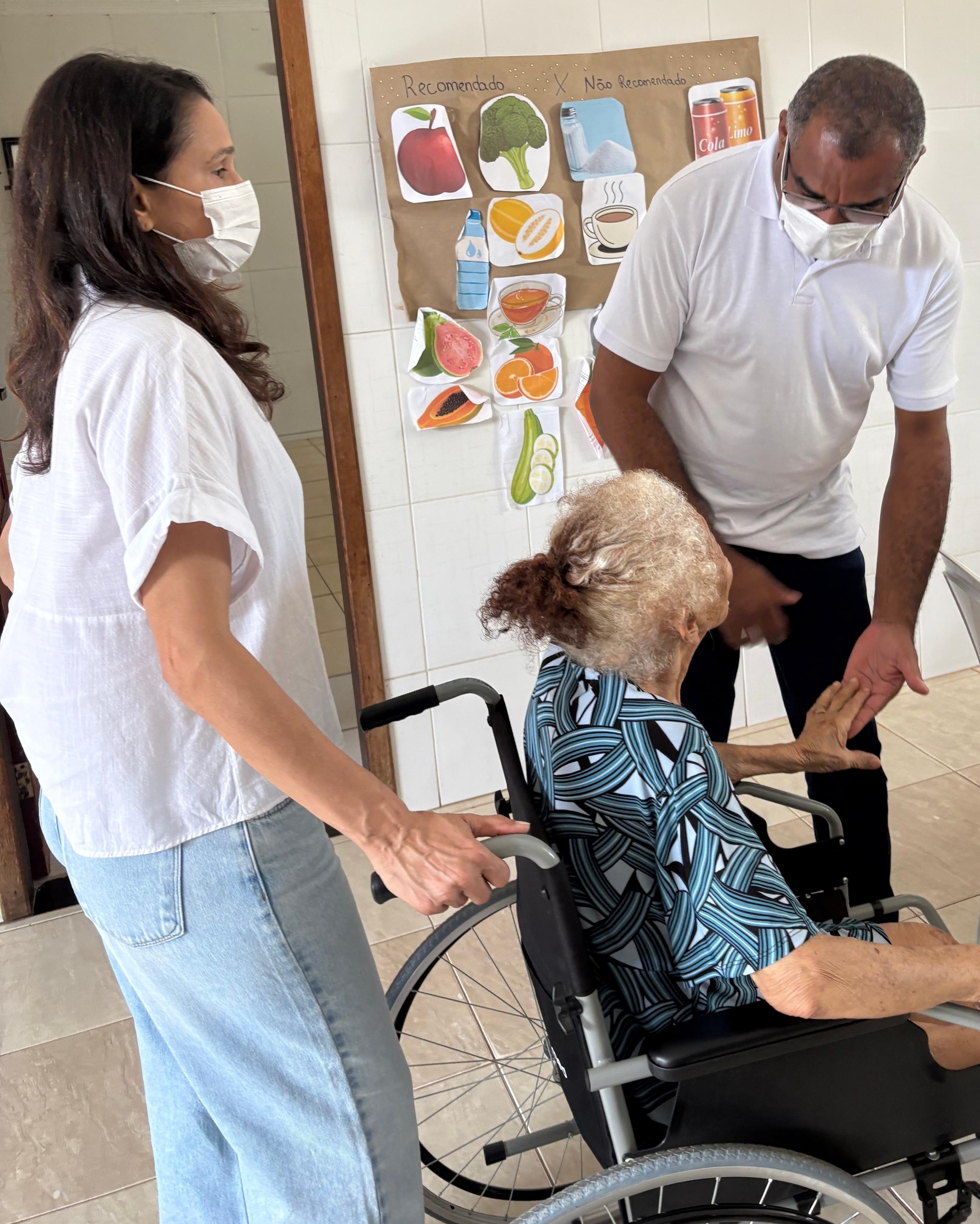 Secretária de Ação Social e da Mulher, Polyanna Siqueira Campos e o secretário-executivo, Amilson Rodrigues com uma idosa acolhida na instituição