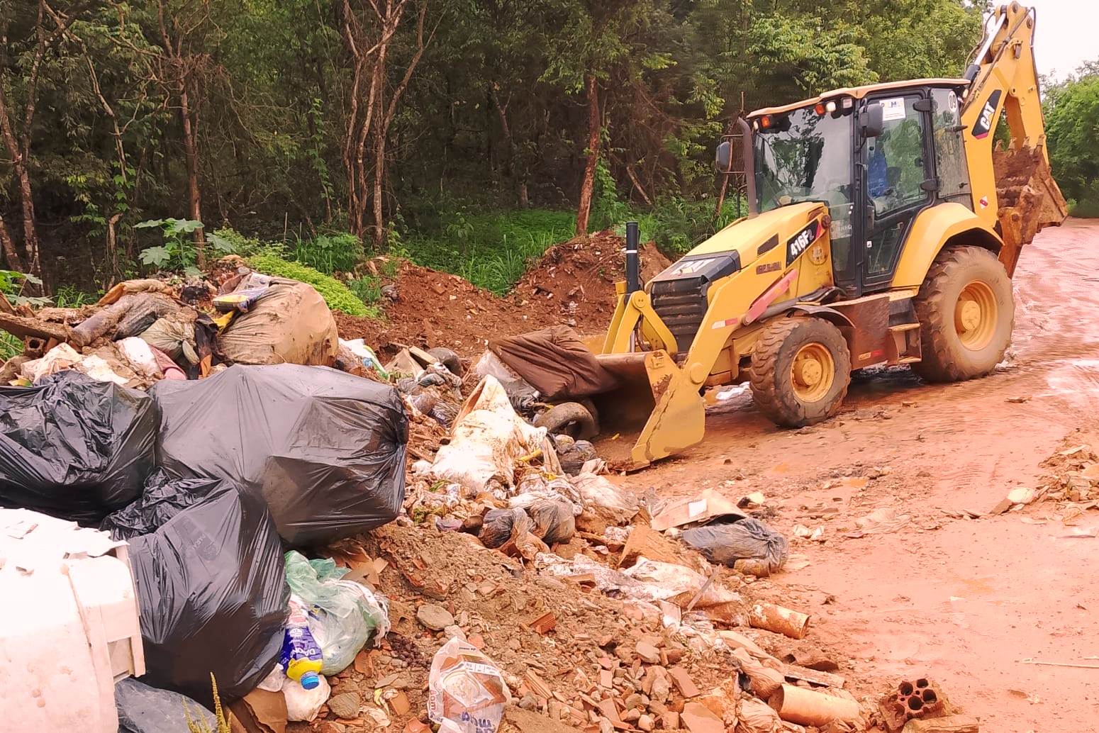 Com ajuda de máquina retroescavadeira, equipe retira grande quantidade de entulhos no setor Água Fria