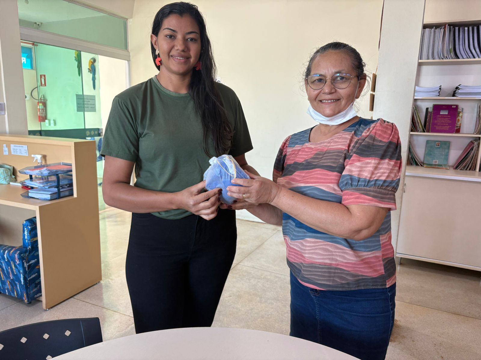 Dona de casa Márcia Lopes da Silva recebe kit do filho, Ruan Lopes Ferreira, do 5º ano