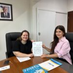Secretária de saúde Dhieine Caminski com o termo junto a delegada da Abeso, Marcela Maia Pitaluga